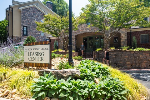 a building with a leasing center sign in front of it